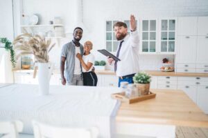 A couple sorts labeled boxes and household belongings in a bright, uncluttered living room.